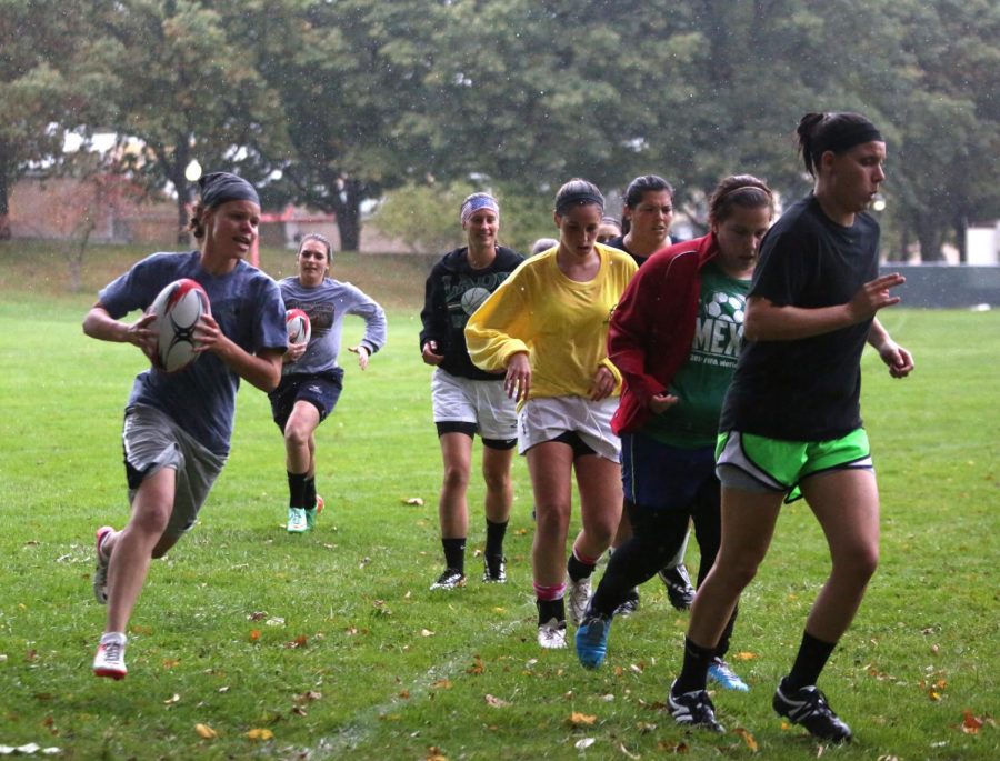 The Kent State Women's Rugby Club run around the field outside of Taylor Hall to warm up in the rain on October 7, 2014.