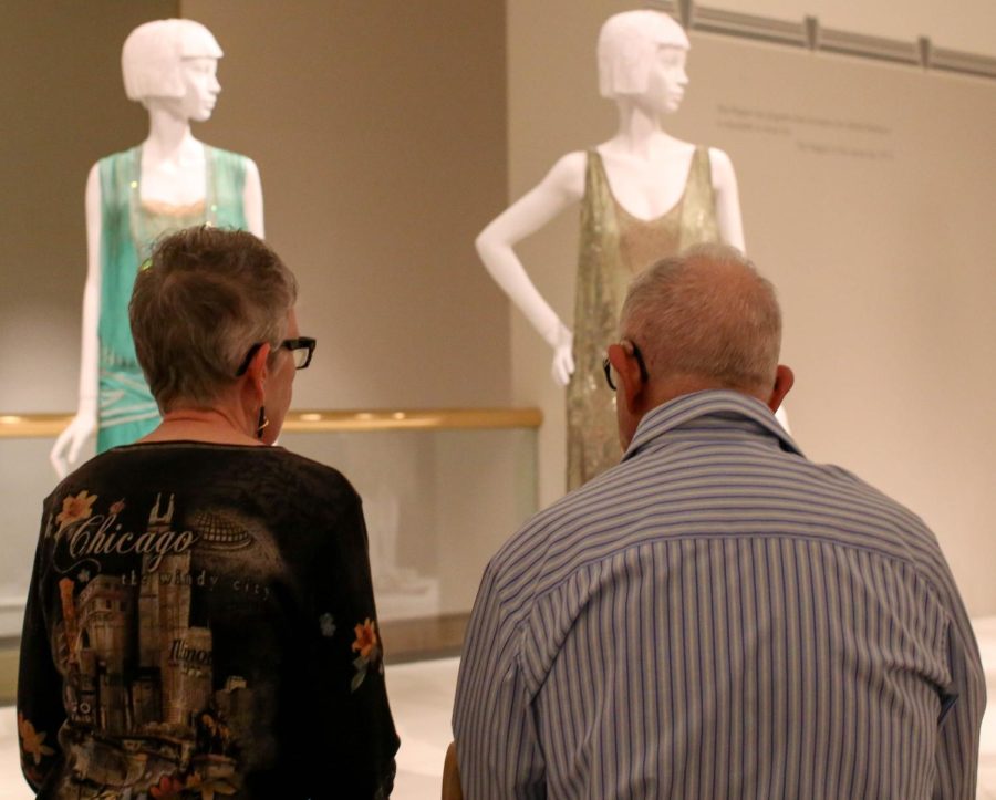 Kent residents Ruth and Syd Crause sit and enjoy the new Flapper Style exhibit at the Kent State Fashion Museum during the opening reception on Thursday Sept. 24, 2015.