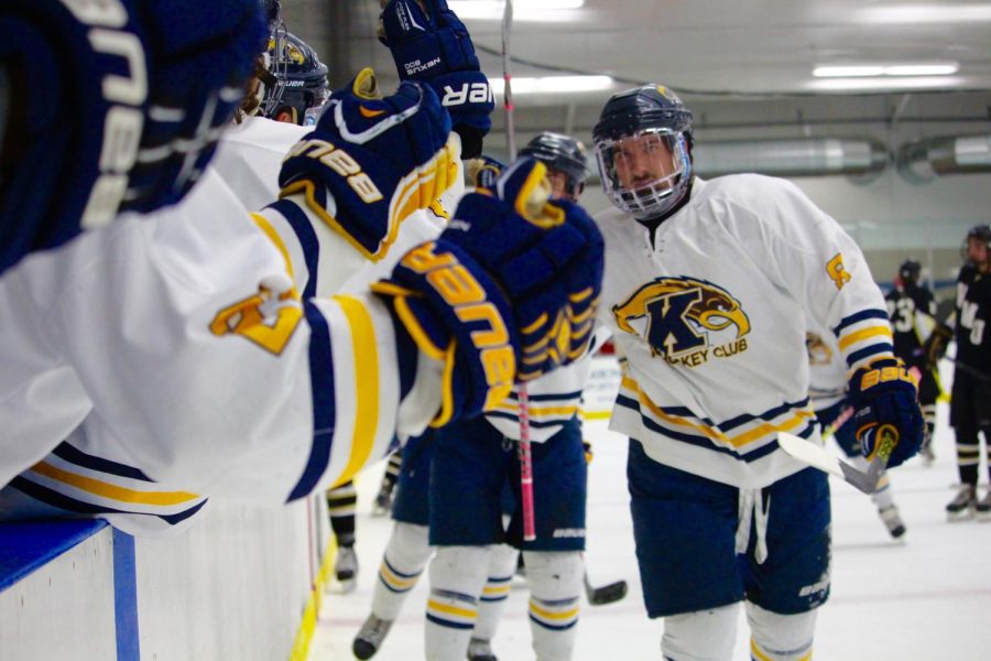 Forward+Jake+Haneline+skates+past+the+bench+for+celebratory+high+fives+after+the+team+scored+on+Western+Michigan+University+Friday%2C+Oct.+9%2C+2015.