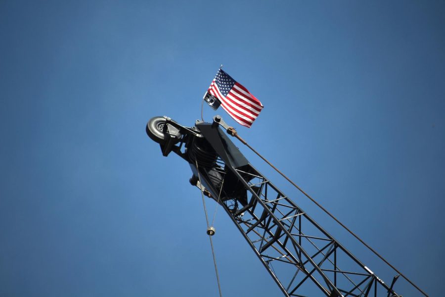 An American and a POW MIA flag sits on top of a crane inside the new College of Architecture & Environmental Design construction zone Wednesday, Oct. 21, 2015.