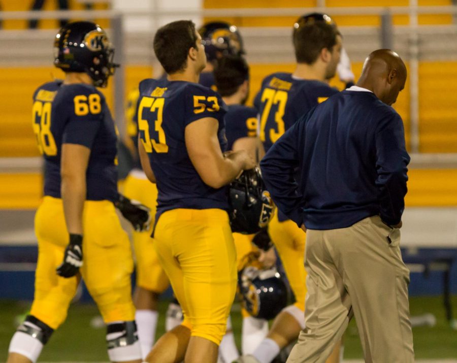 Head coach Paul Haynes walks off the field with his players after losing to the University at Buffalo on Thursday Nov. 5, 2015. The Flashes lost 18-17.