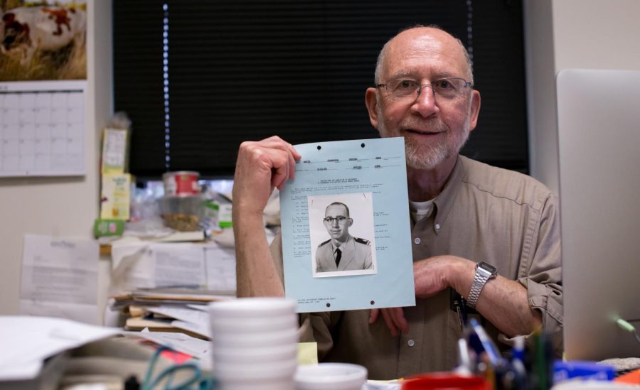 Professor David Riccio holds a photo of himself taken in 1963 two years prior before starting his tenure at Kent State on Tuesday Nov. 10, 2015.