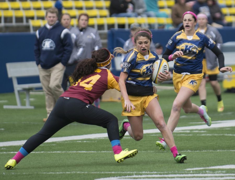 A Kent State womens rugby player tries to break through a Central Michigan defenders tackle to score a try during their game at Dix Stadium on Saturday, Oct. 17, 2015. Kent state went on to win big against Central Michigan with a final score of 81-10.