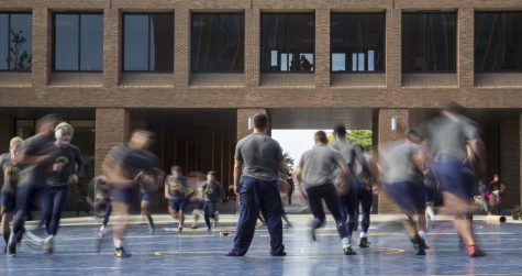 Members of the Kent State Wrestling team jog around the mats set up in Risman Plaza for their third annual outdoor wrestling practice. Oct. 12, 2015.
