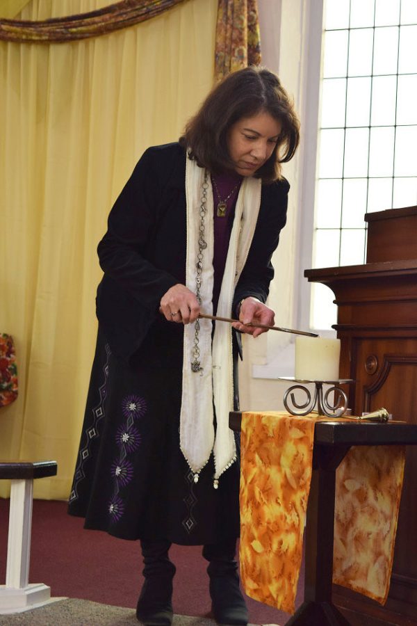 Christie Anderson lights the candle representative of lasting peace at a prayer gathering at the Unitarian Universalist Church on Nov. 29, 2015.