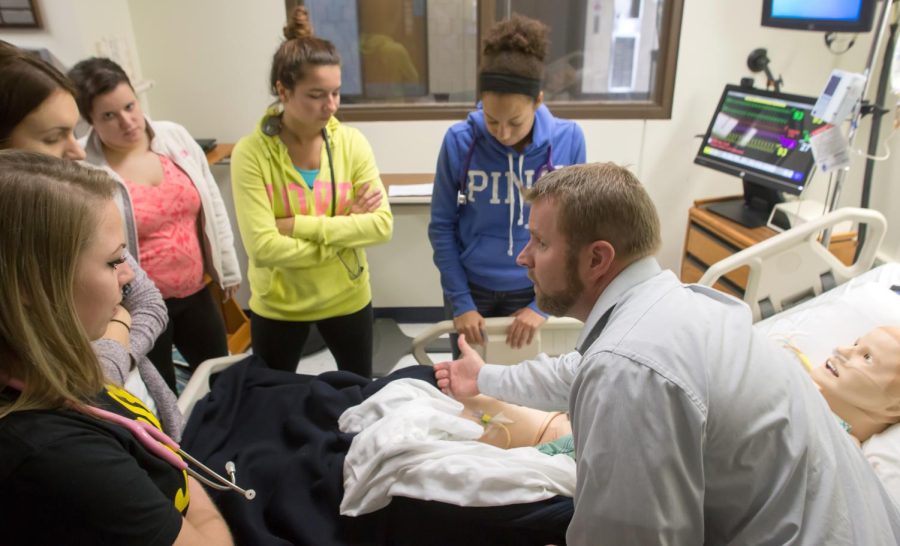 Professor Jeremy Jarzembak shows his students how to take a urine sample from a catheter at Henderson on Friday Nov. 6, 2015.