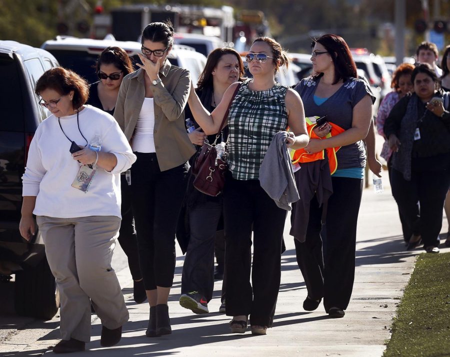 People evacuate the scene of a mass shooting at the Inland Regional Center in San Bernardino, Calif., on Wednesday, Dec. 2, 2015.