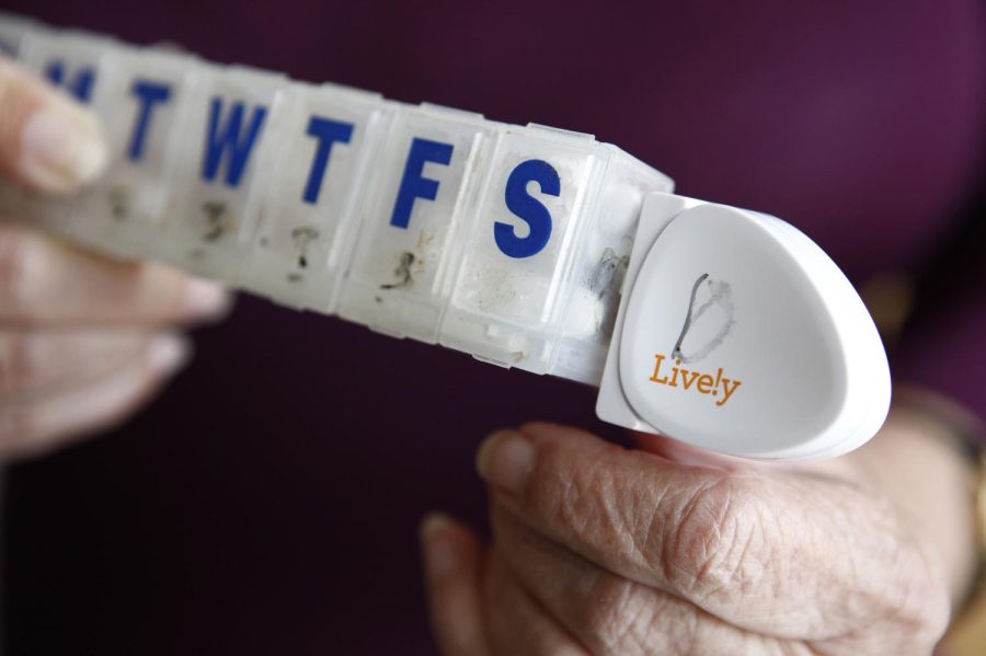Dorothy Dworsky holds her pill case with an attached Lively activity sensor on May 16, 2014 at her home in San Francisco, Calif.