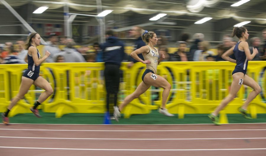 Competitors in the women’s mile make the turn toward the finish line during a dual meet at the Kent State Field house between Kent State and Akron on Friday, Jan. 22, 2016. The lady flashes fell to the Zips 80-71.