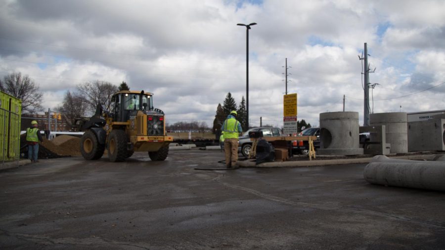 Construction workers work in the parking lot outside of the Recreation Center on Wednesday, Feb. 3, 2016.