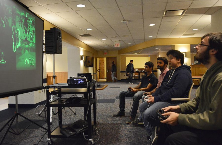 (from left) Graduate computer science major Raujit Chennam, Graduate digital science major Sourov Shrivartova, freshman game design major Tyson Chim, and sophomore accounting major Jason Miller play Mario Kart at the Cyber Game Night beneath the Student Center on Monday, Feb. 1, 2016.