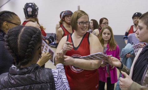 Sarah Dombrosky, a skater for the Rubber City Rollergirls, signs autographs after the first bout of the season at the John S. Knight Center in Akron, Ohio on Saturday, Feb. 6, 2015. 