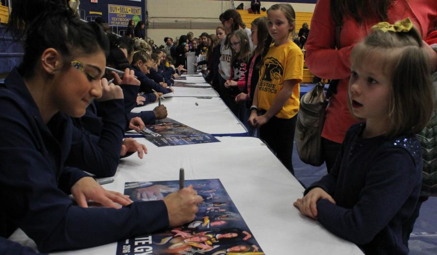 Sophomore Michaela Romito signs a poster for a little girl after the home meet against BGSU on Sunday, Feb. 21, 2016.