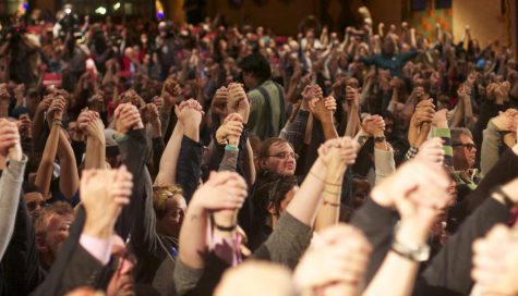 Bernie Sanders supporters hold their hands in the air in an interfaith prayer before the rally lead by Kyle Earley at Akron Civic Theater on Monday, March 14, 2016.