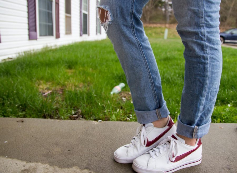 Junior fashion merchandising major Rachel Habegger shows off her white and red Nikes on Thursday March 31, 2016. Sneakers like Nike and Adidas are becoming popular trends in fashion.