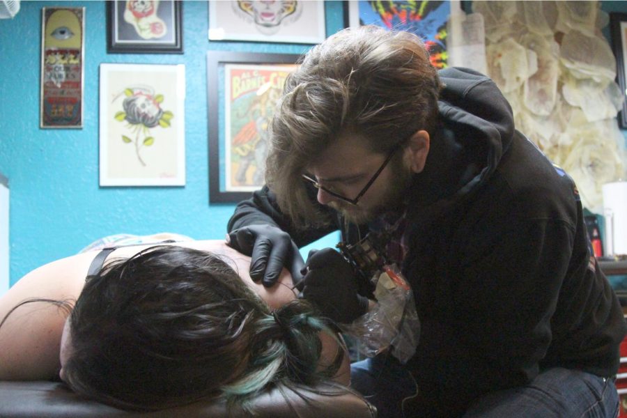 Chase Ogle, 28, tattoos Kent State sophomore Regan Ferrell, 20, at Defiance Tattoo in downtown Kent on Tuesday, April 12, 2016.