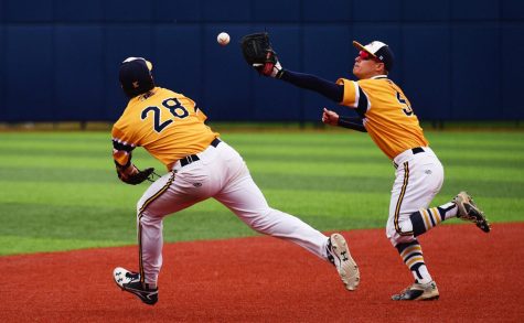 Sophomore infielder Dylan Rosa, left, and junior infielder Sam Hurt, right, chase after a bouncing ball in the game versus Western Michigan University on Saturday, April 2, 2016. The Flashes won 9-7.