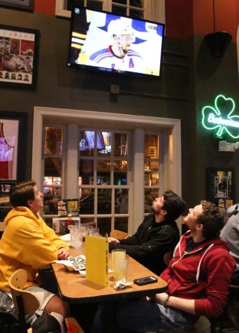 Max McCarty / The Kent Stater Kent State students Joe and Mike Sullivan and Sky Buller sit and watch the first night of the NHL playoffs at Buffalo Wild Wings on Wednesday, April 13, 2016.