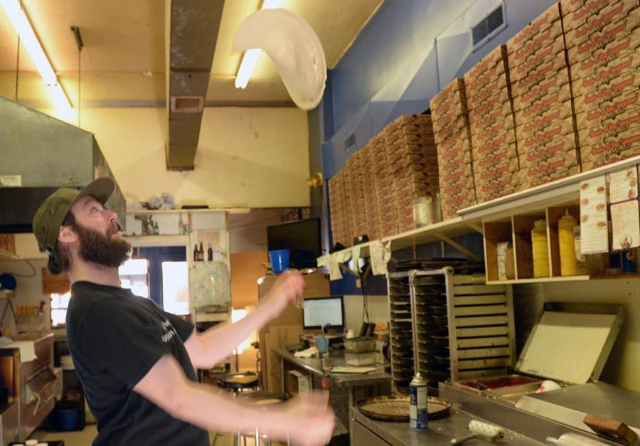Joshua Weiss begins the process of making a pizza by spinning the dough in the air at Guy’s Pizza in downtown Kent on Tuesday, April 19, 2016.