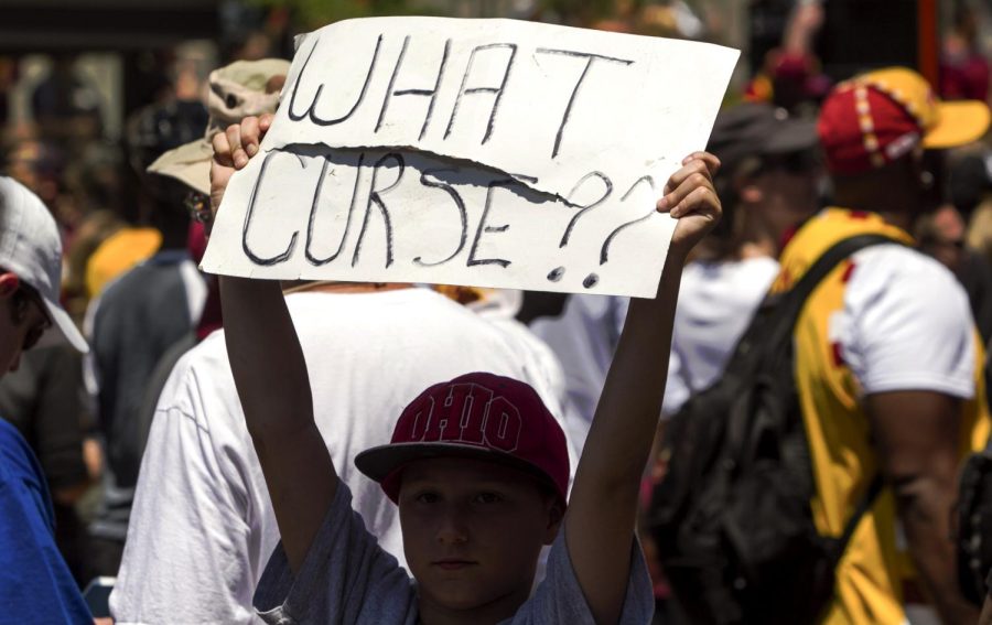 Twelve-year-old Seth Deluise of Cleveland, Ohio, holds up a sign he found on the ground at the Cavaliers’ victory parade in downtown Cleveland on Wednesday, June 22, 2016.