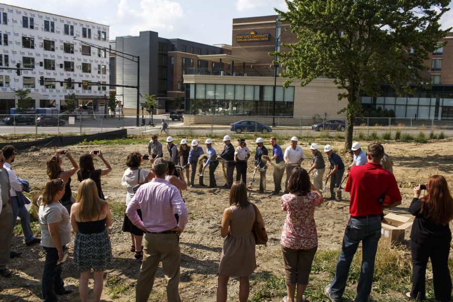 Spectators take photos as members of Kent States architectural department break ground on the new police station on Tuesday, July 12, 2016.