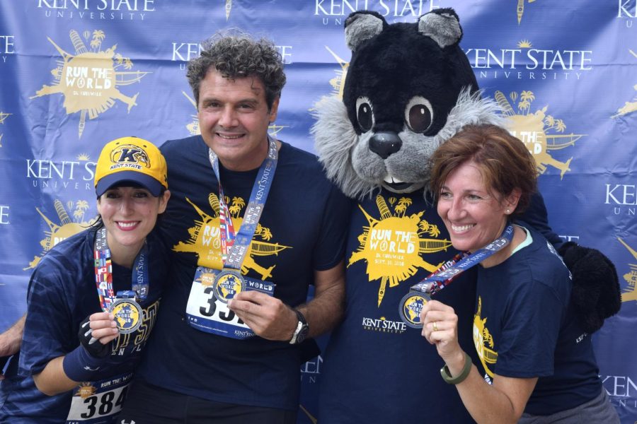 Kayla McMillen / The Kent Stater Kristin Stasiowski, Fabrizio Ricciardelli, and Nicoletta Peluffo pose with the black squirrel mascot after the Run The World 5k Sep. 10 2016. Fabrizio and Nicoletta came to the race representing Florence and the study abroad program in Italy.