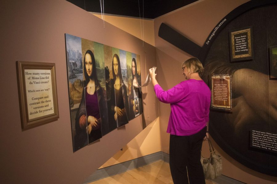 Paula Conger interacts with a painting at the Mona Lisa 4x Exhibit in the Kent State Univeristy Library Thursday, September 15, 2016.