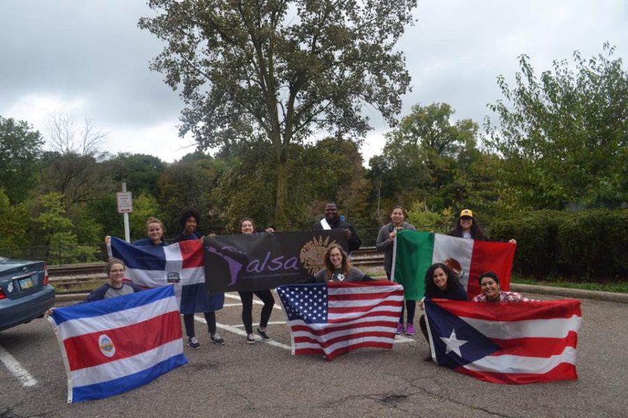 The Kent State Spanish and Latino Student Association (SALSA) holds flags representing different countries at the Homecoming parade on Saturday, Oct. 1, 2016.