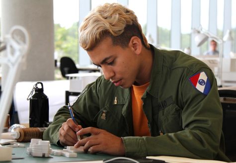 Sophomore architecture major Kasey Montazeri, wearing a shirt and jacket he designed for his custom clothing line, works on a project in the new College of Architecture and Environmental Design building on Thursday, Sept 29, 2016. 