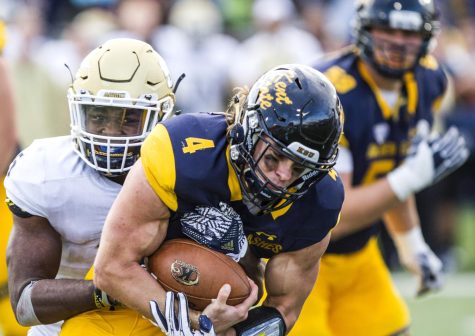 Junior quarterback Nick Holley is tackled by Akron linebacker Ulysees Gilbert III during the second half of the Battle of Wagon Wheel on Saturday, Oct. 1, 2016 at Dix Stadium. Kent State lost to Akron, 31-27.