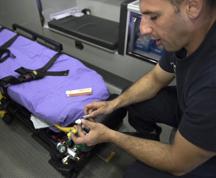 Jake Robinson, a firefighter/paramedic with the Kent Fire Department, demonstrates how to use Naloxone when confronted with a heroin overdose in the back of an ambulance Tuesday Oct. 18, 2016.