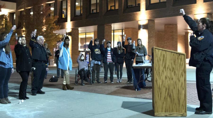 Kent State community members  gathers at the Rise up to Heroin/Opiate Addiction vigil on Risman Plaza on Tuesday, Oct. 25, 2016, holding up their “candles” at the end of Community Resource Officer Tricia Knoles’ speech.