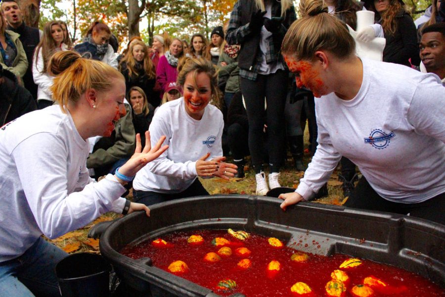 (from left to right) Alex Brooks, 21, Deanna Gifford, 20, and Alli Petit, 19, all of the Alpha Xi Delta sorority, talk strategy while bobbing for gourds on Sunday, Oct. 18, 2015. 