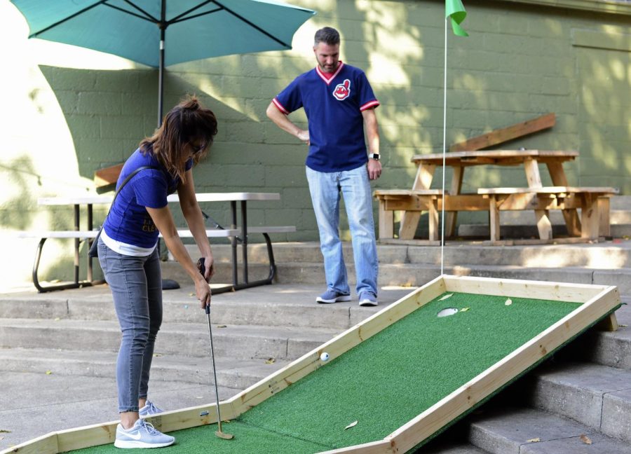 Local residents Teresa and Scott Simone putt-putt at Zephyr Pub in Kent, at the annual Putt Around Downtown event on Saturday, Oct. 15, 2016. 