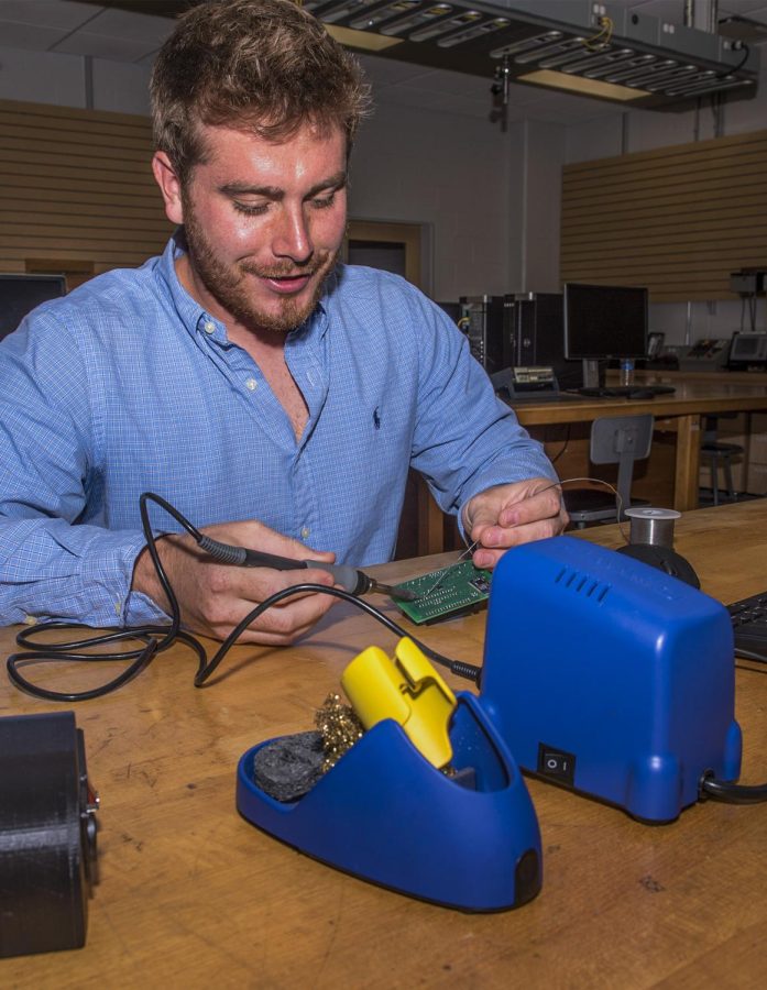 Senior applied engineering major A.J. Morganti displays the electronic components of his invention, which helps to heat and regulate materials used in water pipes and hookahs. He also developed a phone app that controls the device wirelessly. Wednesday, Oct. 12, 2016 in the Aeronautics and Technology Building.