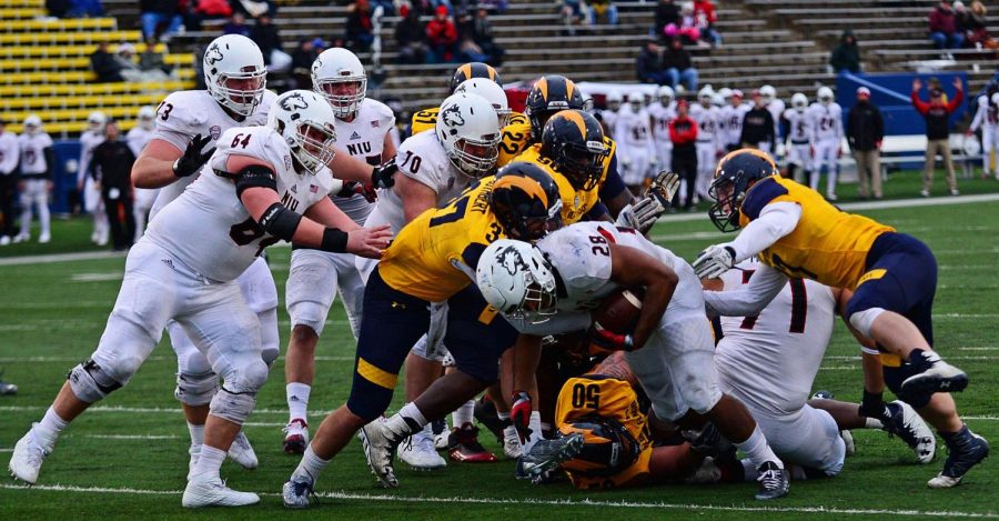 Northern Illinois University senior running back Joel Bouagnon gets tackled while running for a touchdown during the second half of the game against Kent State University on Friday, Nov. 25, 2016.