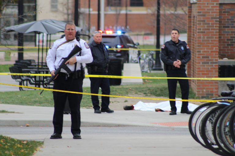 A police officer and two other emergency personnel stand near a body lying near the Chemical Biomolecular Engineering and Chemistry building on OSUs North Campus on Monday, Nov. 28, 2016. 
