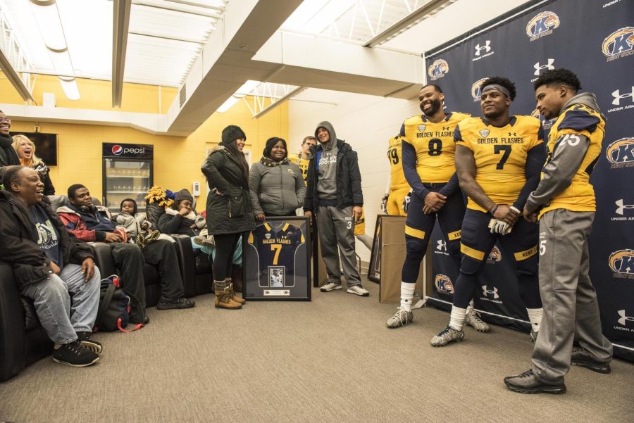 Fifth-year senior Charles Chandler (#8), senior Elcee Refuge (#7), and fifth-year senior  Ernest Calhoun III (#25) of the Kent State mens basketball team pose for pictures as their friends and family watch after the Senior Day game against Northern Illinois University on Friday, Nov. 25, 2016.