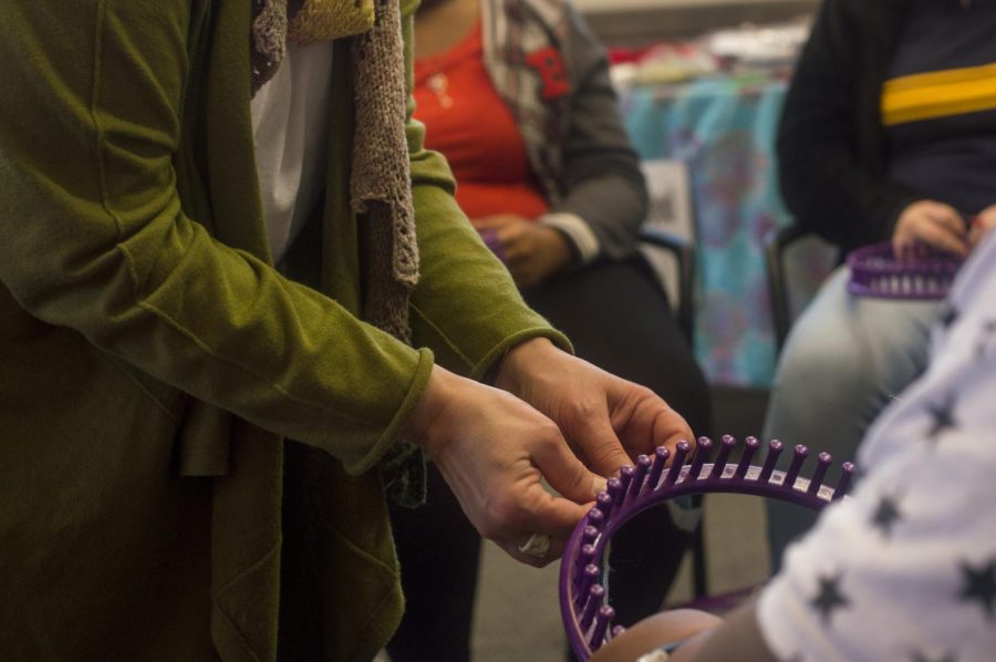 MaryAnn Willoughby, a picture framer, assists a high school student with knitting on a loom during the Hillel MLK Day of Service on Monday, Jan. 16, 2016 . Students and members of the community had the opportunity to come and participate in some fun while doing service for various causes such as Bowling with Special Needs individuals and Knitting for Those in Need.