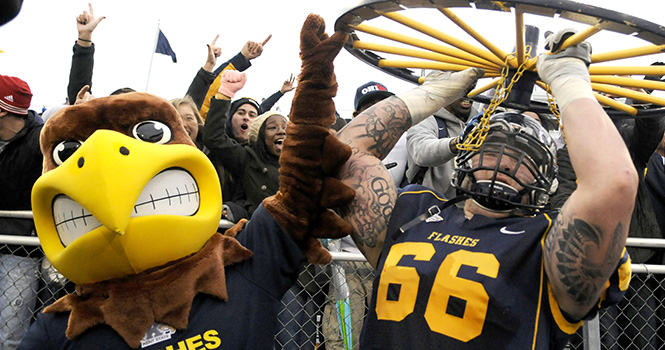 Brian Winters holds up the Wagon Wheel with Flash, after the Kent State football team won the PNC Wagon Wheel Challenge against Akron on Nov. 3, 2013. 