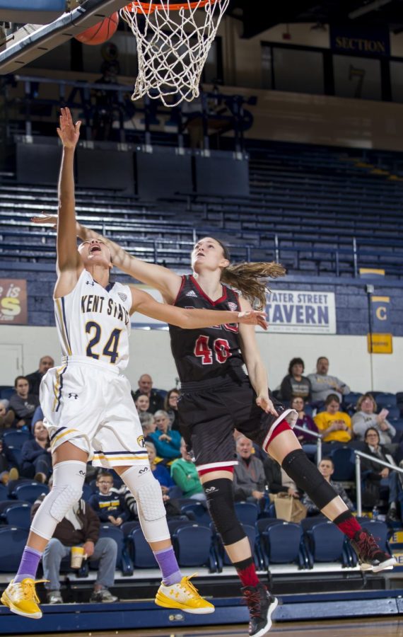 Kent State sophomore guard Alexa Golden lays the ball in against Northern Illinois University redshirt sophomore forward Renee Sladek at the M.A.C. Center on Wednesday, Jan. 11, 2016. Kent State blew a 10-point fourth quarter lead to lose 97-98.