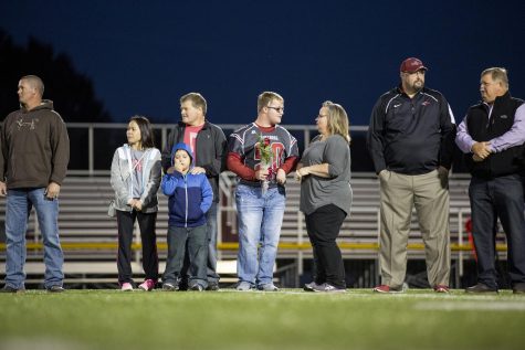 Mother Anne Wallace and step father, Brad Wallace, right and his father Sheldon Mathis left surround Beau at his Senior Night Ceremony.