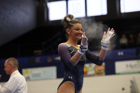 Kent State junior Brooke Timko celebrates after her performance on the uneven bars at a meet against the University of West Virginia at the M.A.C. Center on Saturday, Feb. 4, 2017. Kent State lost 195.950-194.875.