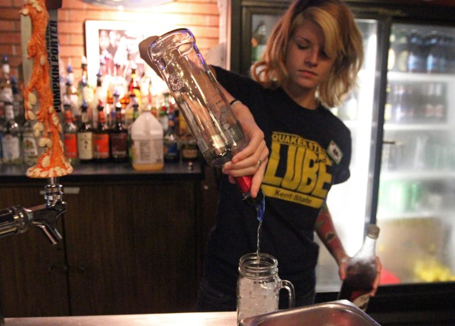 Bartender and senior communication studies major Jennifer Reihner pours raspberry vodka into a spiked pink lemonade drink at Quaker Steak and Lube in the Student Center on Monday, Oct. 5, 2015. Quaker Steak and Lube is the only official place that serves alcohol on campus.