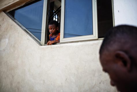 A young girl looks curiously out of a window during a service at the S.D.A. Church in Maamobi, Ghana on March 25, 2017.