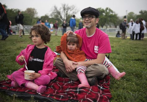 Michael Tomlinson of Virginia and his daughters, 4 year-old Ruth (left) and 2 year-old Twilight sit on The National Mall lawn in Washington, D.C. awaiting the beginning of the March for Science rally on Saturday, April 22, 2017. “The Science March is dear to me because Im a science teacher in Loudoun County. I understand the importance of right thinking and understanding the world. ... I think most scientists are interested in finding the truth. Its important for (my daughters) to see that a lot of people think the same way. Its scary to think we can grow up in a world where people reject simple facts,” Tomlinson said. 