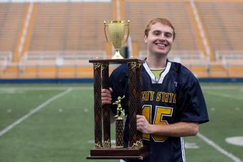 Nick Buzzelli posing with the National College Lacrosse Leagues Midwest North Conference championship trophy after the Kent State mens lacrosse club knocked off Penn State Altoona, 9-5, on April 29 to capture its first title in program history.