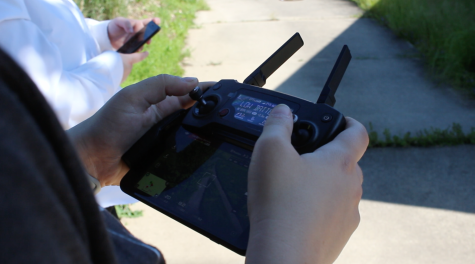 Students in the Small Unmanned Aircraft Systems Aerial Camera Ops course use a controller to pilot a drone on Thursday, June 1, 2017. While piloting, the controller shows what the small aircraft sees and records video to the phone attached.