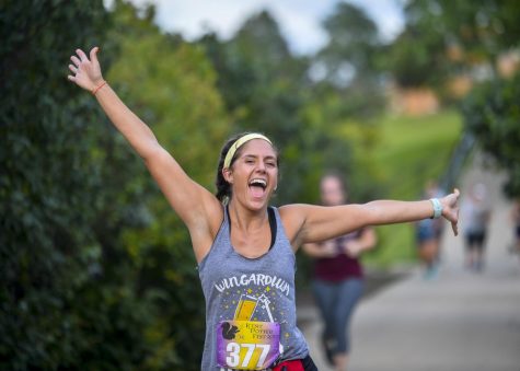 A runner celebrates being over halfway finished at the Potterfest 5k on July 28.