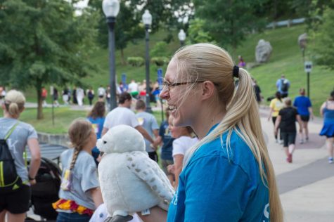 Monique Mullett, 28, from Ravenna, holds a Hedwig puppet as she cheers on runners as a volunteer during the Potterfest 5k on July 28.